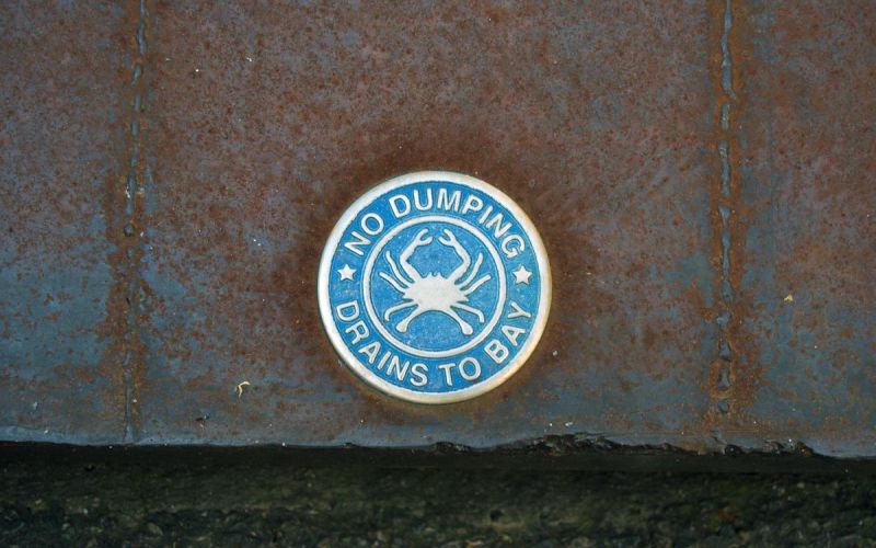 storm drain badge indicating no dumping - drains to bay