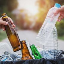 people place plastic and glass bottles into bag, preparing them for CRV redemption