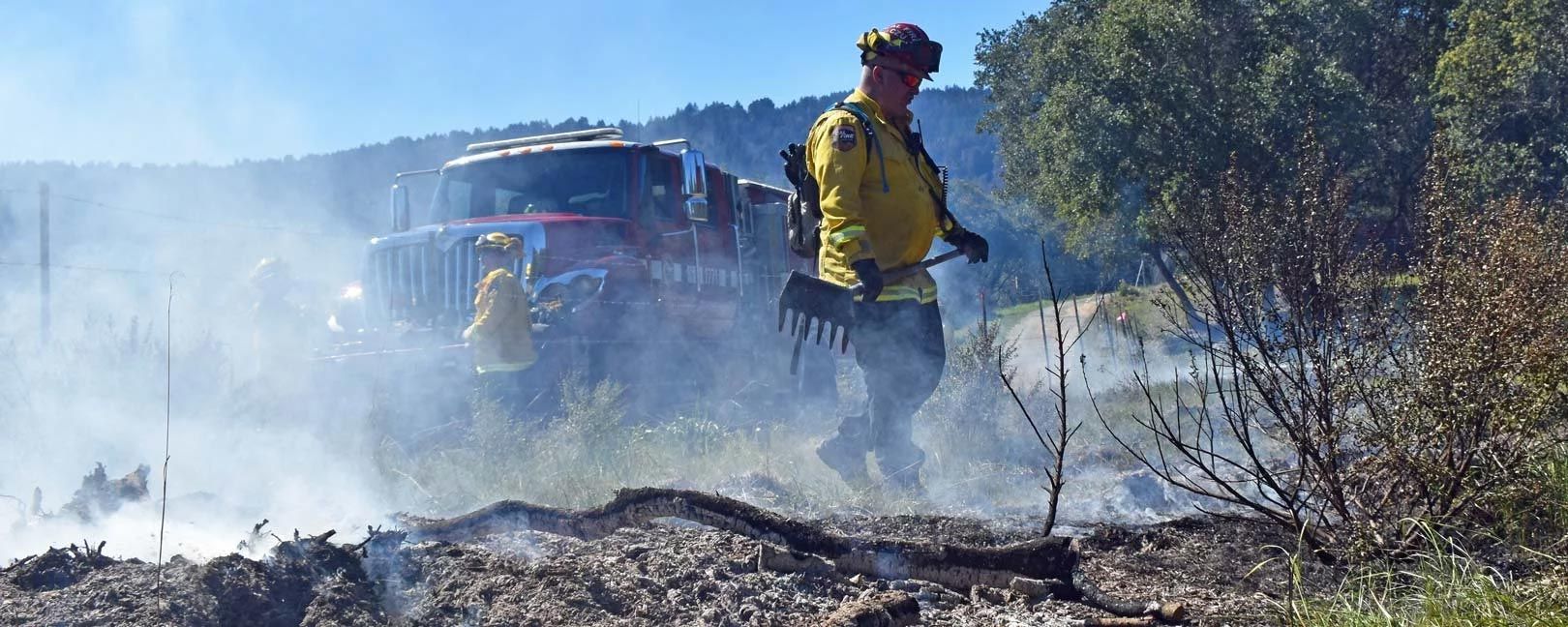 San Mateo County firefighters mopping up a grass fire