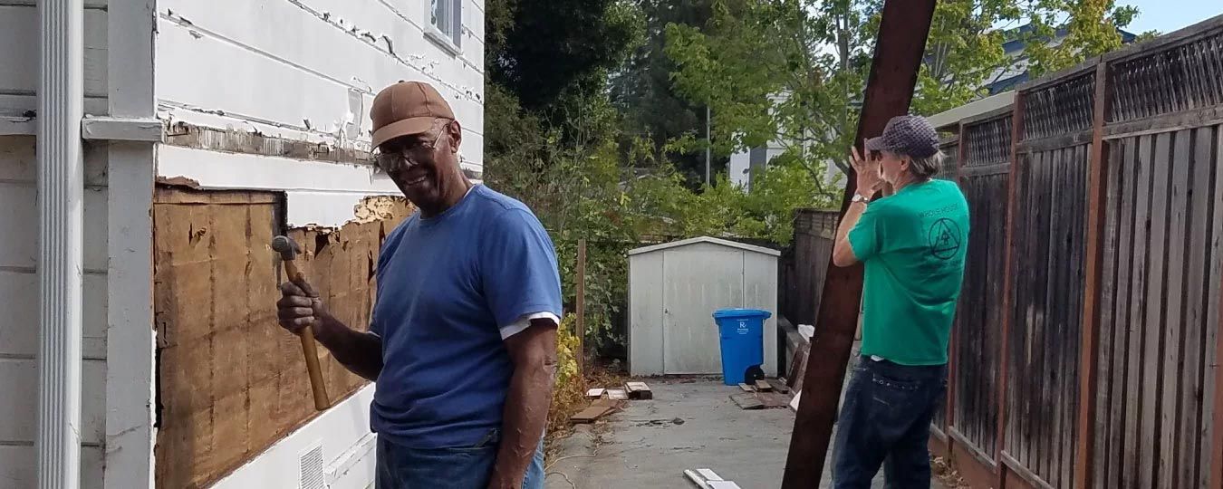 two San Mateo County residents deconstructing the side of a home